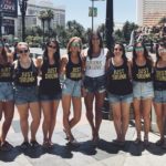 Girls standing for a photo with funny shirts for a bachelorette party. The best time to hire a male stripper.